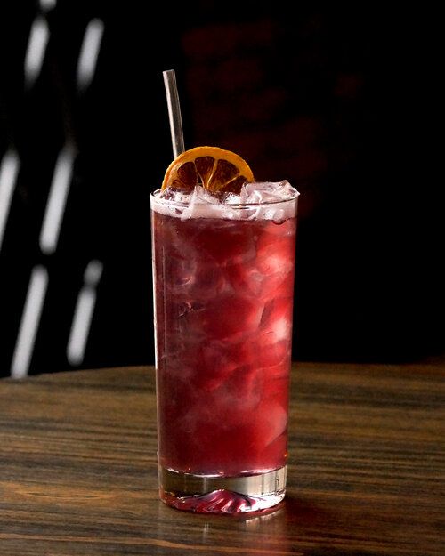 The classic Collins takes on a vibrant hue of Manitoban Saskatoon berries and hibiscus flowers